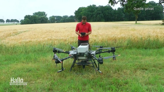 Landwirt Jan-Wilhelm Strampe steht vor einer Drohne, die Pflanzensamen aus der Luft verteilt. © Screenshot 