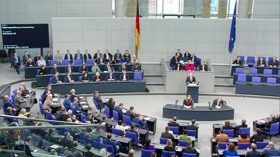Olaf Scholz steht in der Mitte des Sitzungssaals des Bundestags. © Screenshot 