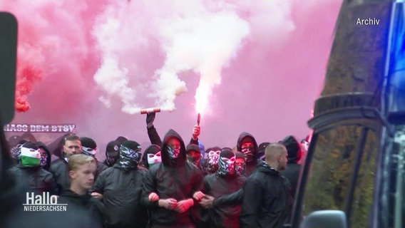 Eine Gruppe vermummte Männer zünden Pyro. © Screenshot 
