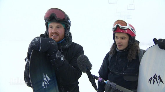 Zwei Personen mit Snowboard im Schnee. © Screenshot 