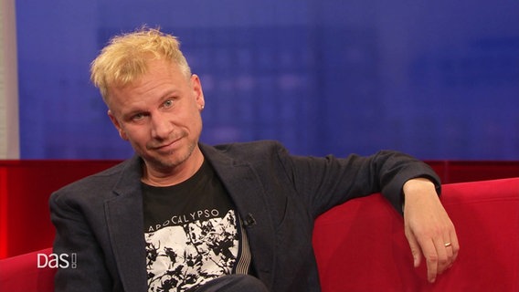 Robert Stadlober auf dem roten Sofa. © Screenshot 
