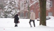 Menschen im Schnee laufen durch eine Straße. © Screenshot 