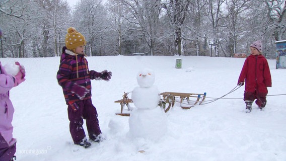 Kinder neben einem Schneeman. © Screenshot 