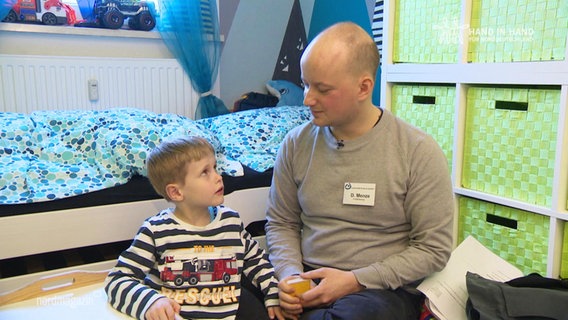 Ein Junge und sein Sprachpädagoge sitzen in einem Kinderzimmer. © Screenshot 