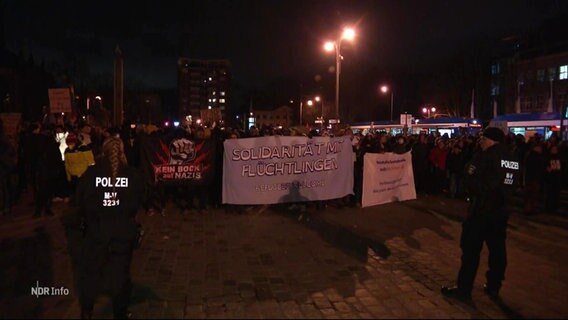 Eine Gruppe von Demonstrierenden mit Schildern und Bannern. © Screenshot 