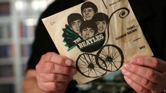 Zwei Hände halten eine Schallplatte von The Beatles in die Kamera. © Screenshot 