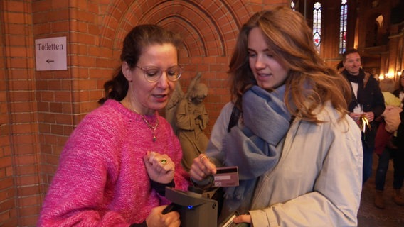 Eine Frau überweist nach dem Gottesdienst die Kollekte mit ihrer EC-Karte. © Screenshot 