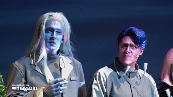 Zwei geschminkte Männer auf einer Theaterbühne. © Screenshot 