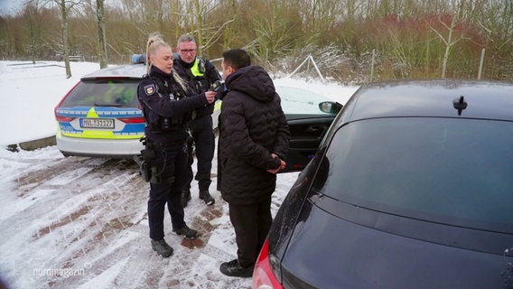 Beamte der Autobahnpolizei sprechen mit einem Mann. © Screenshot 