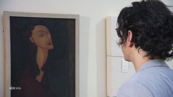 Eine Person steht vor einem gemalten Portrait. © Screenshot 