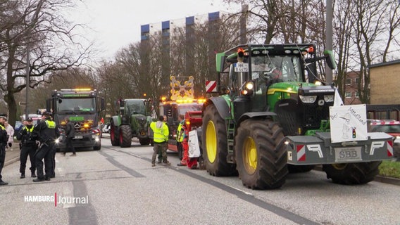 Traktoren und andere Fahrzeuge blockieren eine Straße. © Screenshot 