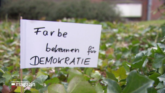 Ein Protestschild mit Aufschrift "Farbe bekennen für die Demokratie" © Screenshot 