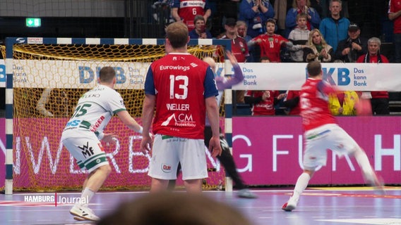 Das Handballspiel HSV gegen Göppingen am 25.02.2024. Ein HSV-Spieler steht mit dem Rücken zur Kamera und schaut auf einen Strafwurf für seine Mannschaft. © Screenshot 