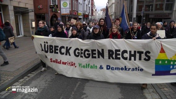 Demonstranten tragen ein Banner mit der Aufschrift: Lübeck gegen rechts. © Screenshot 