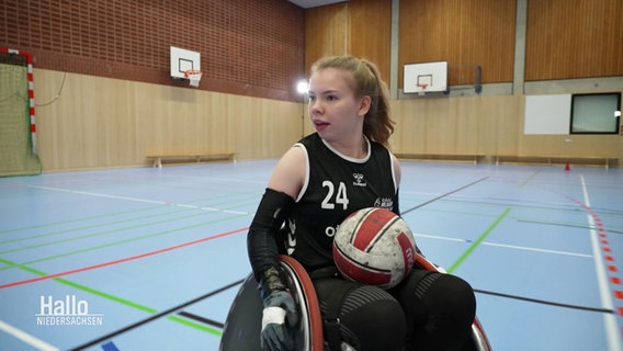 Die Sportlerin Mascha Mosel fährt mit einem Ball im Schoß in ihrem Rollstuhl. © Screenshot 