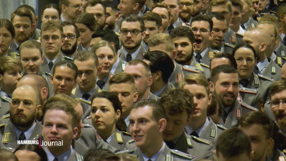 Soldat:innen in Reihen nebeneinander sitzend. © Screenshot 