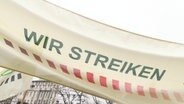 Auf einem Banner steht."Wir Streiken". © Screenshot 