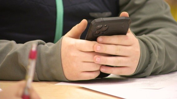 Ein Jugendlicher hält sein Smartphone in den Händen. © Screenshot 