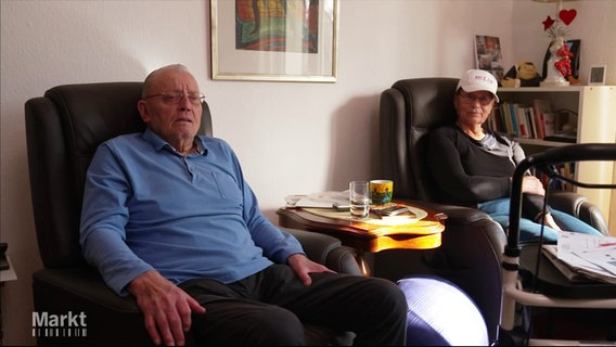 Zwei alte Personen sitzen in Sesseln in ihrem Wohnzimmer. © Screenshot 