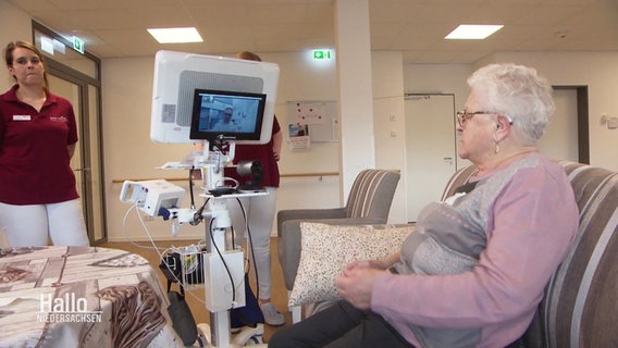 Eine ältere Dame ist über einen Monitor mit einem Arzt verbunden. © Screenshot 