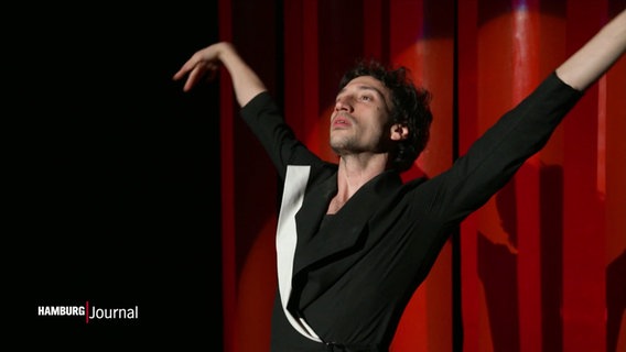 Ein Performancekünstler hebt seine Arme. © Screenshot 