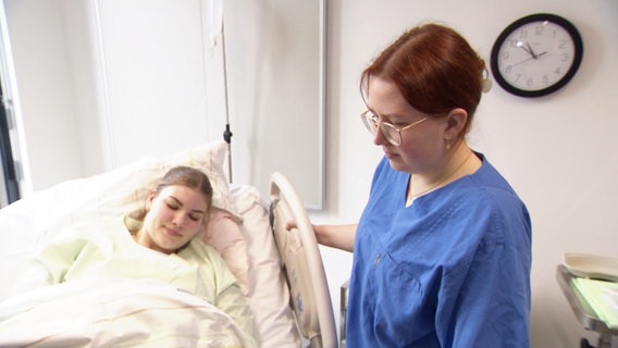 Eine angehende Hebamme steht im Krankenhaus am Bett einer Frau. © Screenshot 