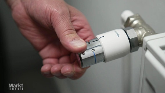 EIne Hand dreht das Thermostat einer Heizung auf. © Screenshot 