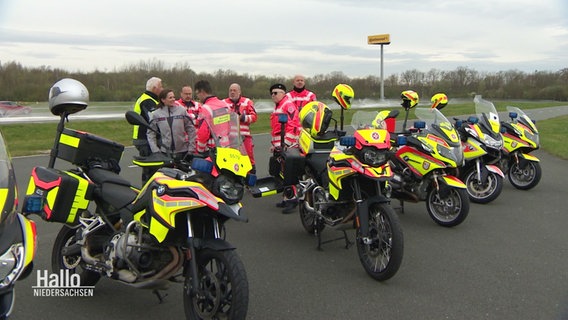 Mitglieder der Johanniter-Motorradstaffel stehen neben ihren Rädern. © Screenshot 