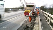 Sanierungsarbeiten auf einer Autobahnbrücke, während der Verkehr weiterrollt. © Screenshot 