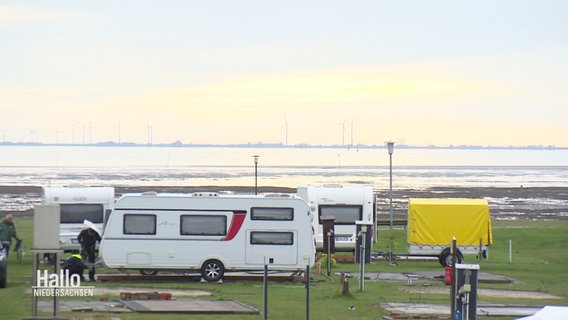 Wohnwägen werden auf einem Campingplatz an der Nordsee platziert. Es herrscht gerade Ebbe. © Screenshot 