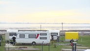 Wohnwägen werden auf einem Campingplatz an der Nordsee platziert. Es herrscht gerade Ebbe. © Screenshot 