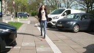 Jasmin Ciplak mit ihrem Blindenstock auf einem Fußweg. © Screenshot 