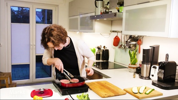 Eine Person in einer Küche am Herd mit einer Grillpfanne. © Screenshot 