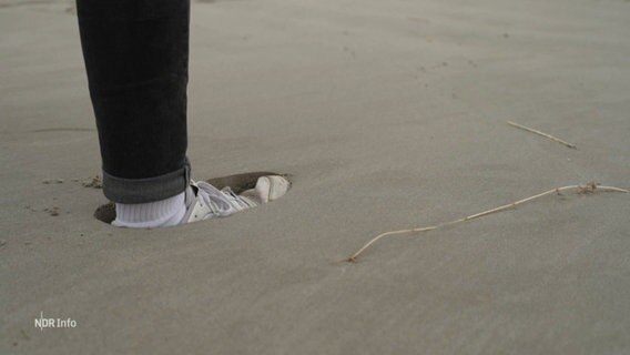 Ein Fuß sackt tief in den Sand ein. © Screenshot 
