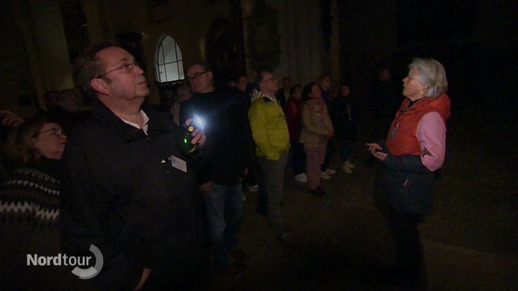 Eine Gruppe Erwachsener bei Nacht im Lübecker Dom. © Screenshot 