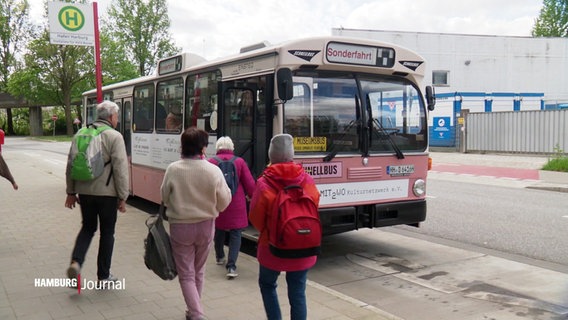 Menschen steigen in einen alten Schnellbus des HVV, wie er in den 70ern gefahren wurde. Der Bus hat eine rosa Lackierung. © Screenshot 
