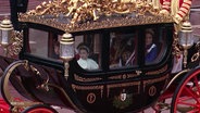 Britische Königsfamilie in vorbeifahrender Kutsche. © Screenshot 