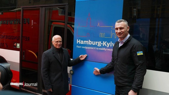 Oberbürgermeister Peter Tschentscher und Vitali Klitschko, Bürgermeister der ukrainischen Hauptstadt Kiew, stehen vor einem HVV-Bus mit dem Logo des Städtepaktes zwischen Hamburg und Kiew. © Screenshot 