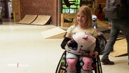 Ein Mädchen im Rollstuhl skatet in einer Skatehalle. © Screenshot 