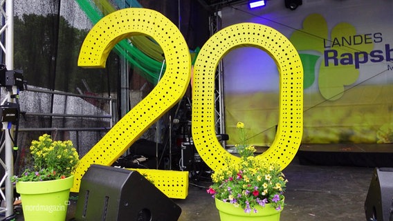 Eine große gelbe 20 steht auf einer Bühne des Landesrapsblütenfests. © Screenshot 