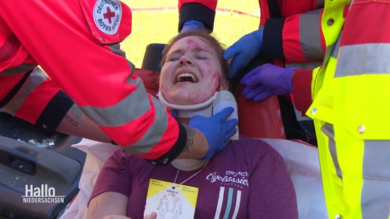 Eine Person bekommt von Rettungskräften eine Halskrause angelegt. © Screenshot 