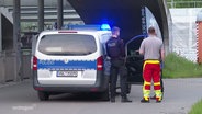 Polizisten stehen in der Unterführung der S-Bahnstation Lütten Klein. © Screenshot 