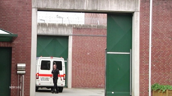 Ein gerade noch offenes Gefängnistor, dahinter zu sehen ein Beamter und ein Transporter. © Screenshot 