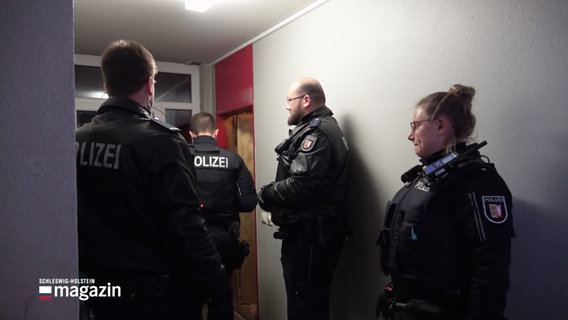 Drei Polizisten und eine Polizistin stehen vor einer Wohnungstür. © Screenshot 