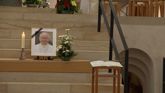 Ein Foto des Papstes Franziskus und ein Kondolenzbuch im Hildesheimer Dom. © Screenshot 