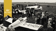 Zahlreiche Besucher stehen um Flugzeuge auf einer Ausstellung  
