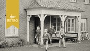 Kinder kommen aus dem Eingang eines Wohnheims (Rauhes Haus) in Hamburg (1958)  