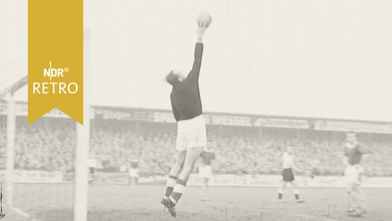Torwart springt hoch und lenkt Ball mit einer Hand ab (Stadion an der Loheide, Lübeck 1959)  