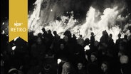 Menschenmenge vor einem großen Biikefeuer auf der Insel Sylt (1961)  