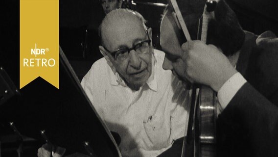Der Komponist und Dirigent Igor Strawinsky spricht während eiber Orchesterprobe mit einem Vioinisten (1965)  
